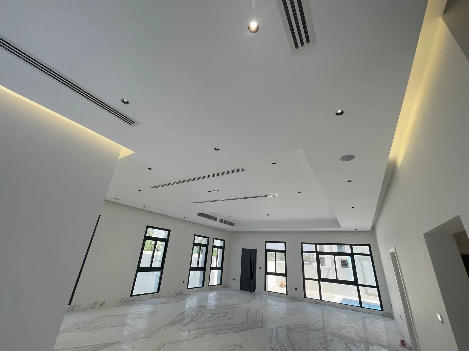 Living area with cove lighting and marble floors